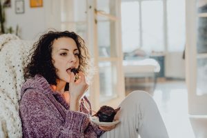 жінка їсть солодощі